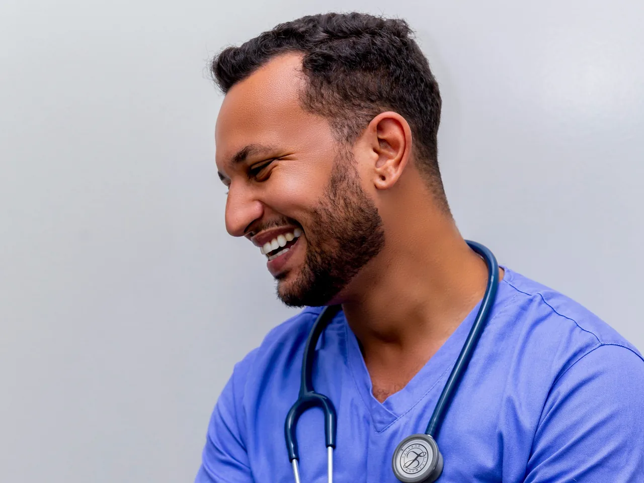 Smiling physician in scrubs with a stethoscope